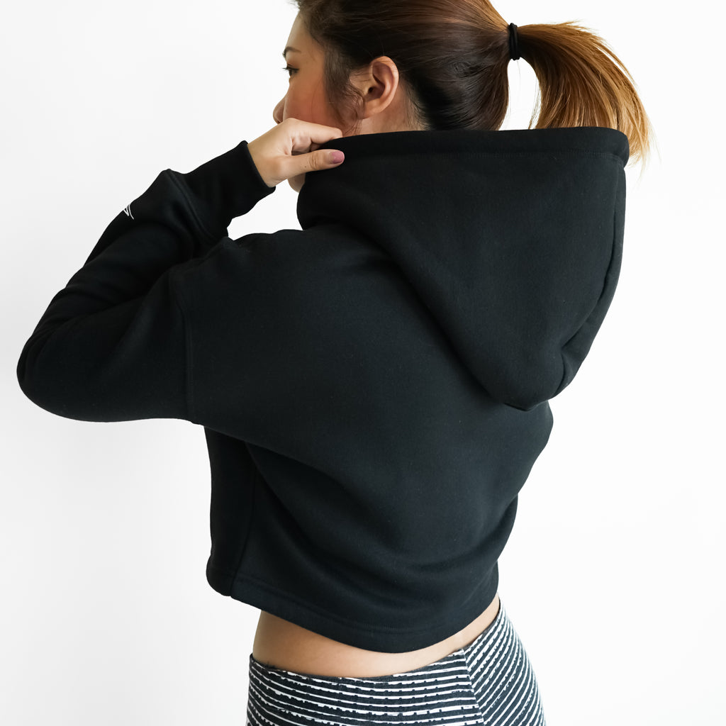 woman in a black cropped hoodie and leggings