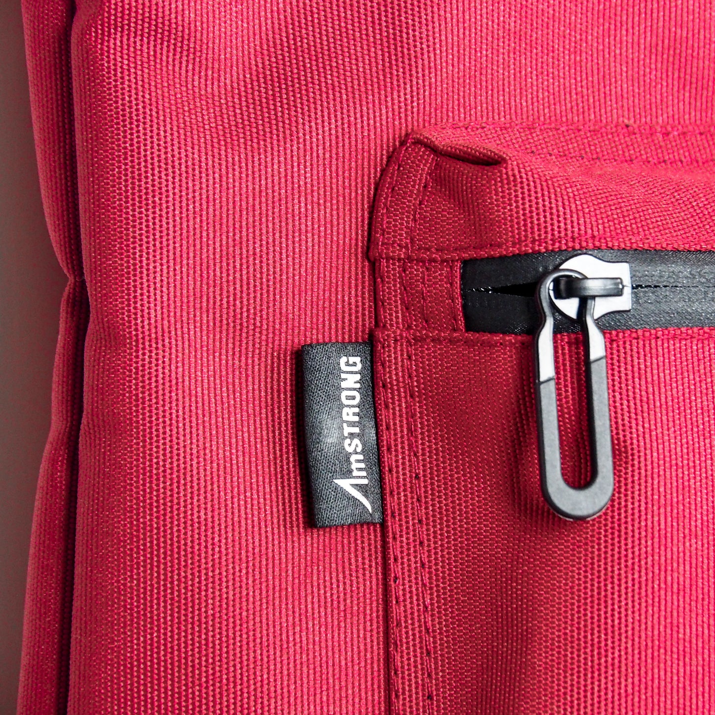 AmSTRONG woven label and waterproof zip on red fabric
