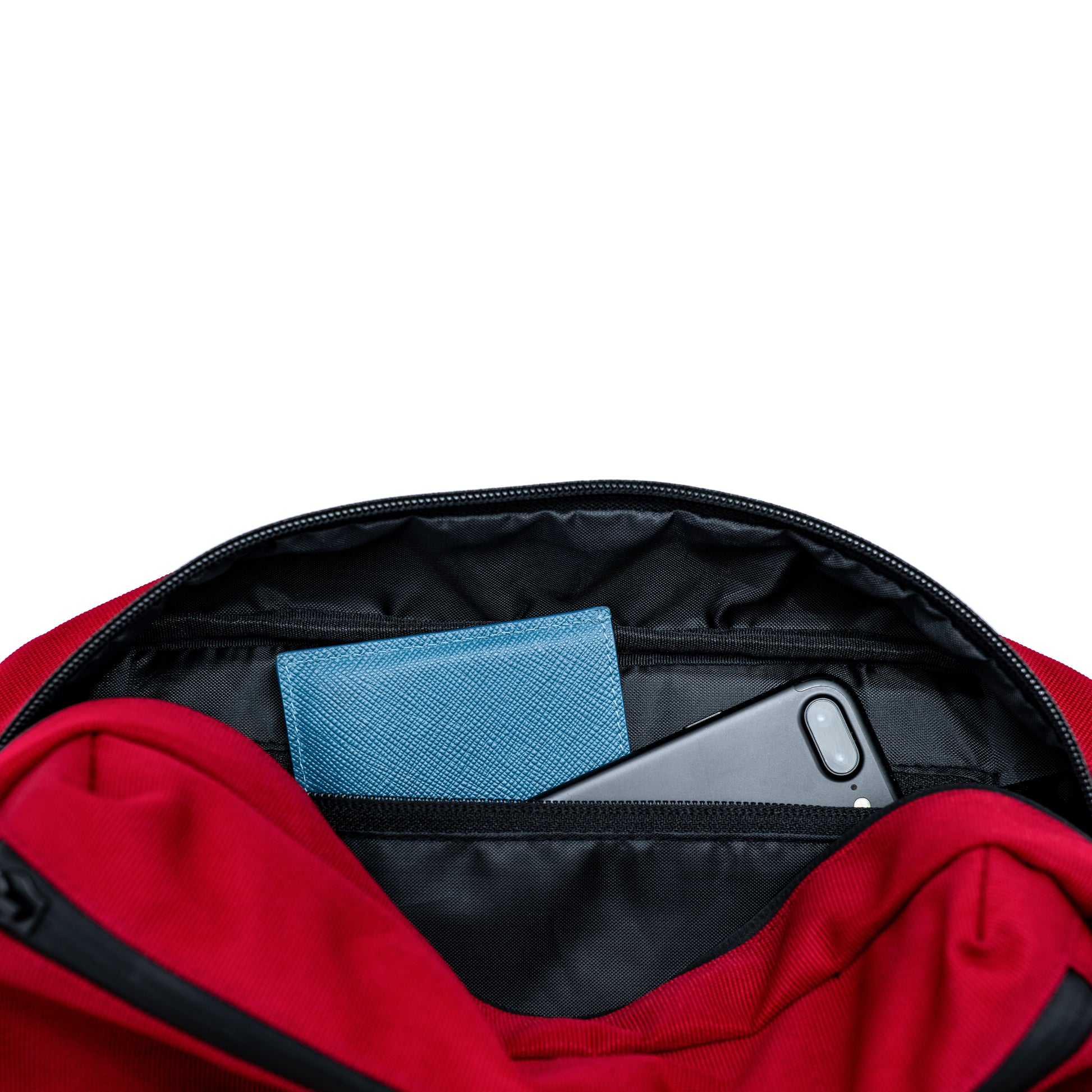 an iPhone and green cardholder stashed in a zippered pocket